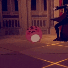 a person is standing next to a pink ball with a face on it .