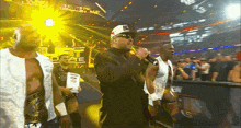a man singing into a microphone in front of a sign that says ultimate warrior