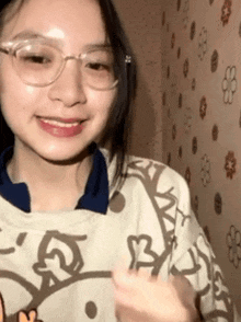 a girl wearing glasses and a shirt with the letter b on it smiles