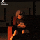 a tiktok video of a person sitting in a chair looking at a cellphone