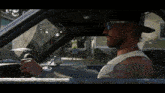 a man wearing sunglasses and a hat driving a car