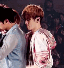 a couple of men are standing next to each other in a crowd .