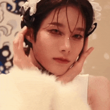 a close up of a woman 's face with a white fur coat on .