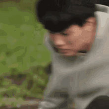 a young man in a hoodie is sitting on the ground .