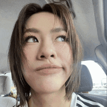 a close up of a woman 's face with her eyes looking up