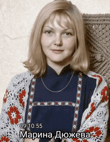 a woman wearing a blue shirt and a white sweater has the date 09.10.55
