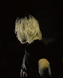 a woman with long blonde hair is wearing a black shirt that says nirvana