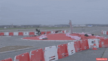 a car is driving around a roundabout with a sign that says thinki jules on the bottom