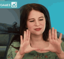 a woman is making a heart shape with her hands in front of a screen that says games