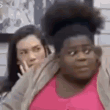 two women are sitting next to each other in a room .