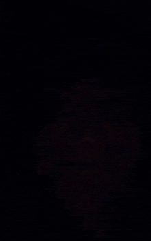 a close up of a person 's face in the dark with a smile on their face .