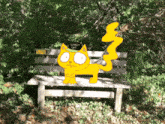 a scaredy cat sits on a park bench in the woods