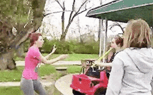 a woman in a pink shirt is standing next to a woman in a gray hoodie .