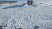 a trailer is stuck in the snow and a snowboard is on the ground