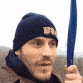 a man wearing a us hat holds a blue object