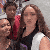three women are posing for a picture in front of a sign that says ' a ba boy ' on it