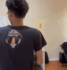 a person wearing a black t-shirt with a picture of a rabbit on the back