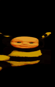a baby doll in a bee costume looks at the camera with a black background