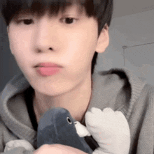 a close up of a young man holding a stuffed animal .