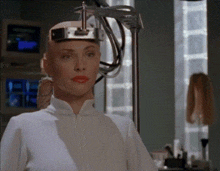 a woman wearing a white shirt has a device on her head that looks like a camera