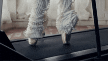 a person wearing a pair of white shoes with pearls on them is running on a treadmill