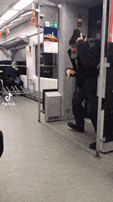 a man with a beard is standing on a train with tiktok written on the bottom right corner