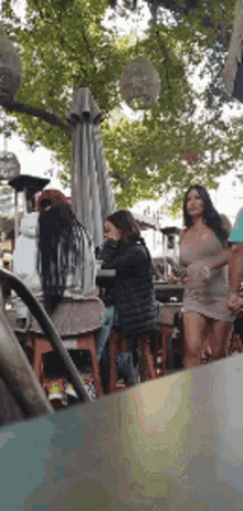 a woman in a short dress is standing in front of a table in a restaurant .