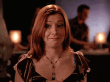 a woman with red hair and a necklace is making a funny face