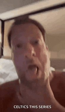 a man is making a funny face with his tongue out and the words celtics this series written below him .