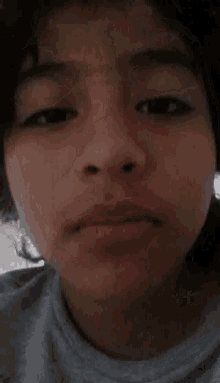 a close up of a person 's face with a gray shirt