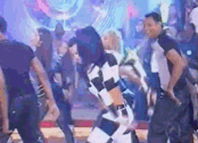 a group of people are dancing on a stage in a nightclub .