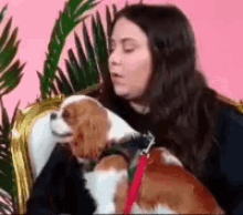 a woman sitting on a couch with a dog on her lap