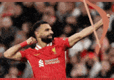 a man wearing a red shirt that says standard chartered