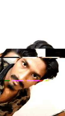 a man with a beard and mustache is looking at the camera with a green screen in the background .