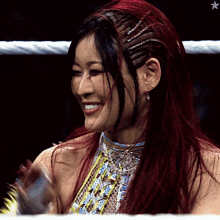 a woman with red hair is smiling in a ring with a star in the background