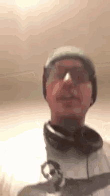 a man wearing a green hat , headphones , and glasses is making a funny face .