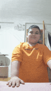 a boy wearing an orange shirt that says angel on the front