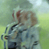 a blurry picture of two people standing next to each other in a field