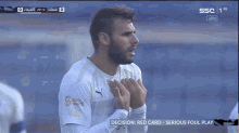 a soccer player stands in front of a screen that says serious foul play
