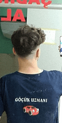 a man wearing a shirt that says gocuk uzmani on the back