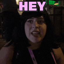 a woman in a black shirt with the word are above her head
