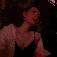 a woman in a white shirt is standing in a red light