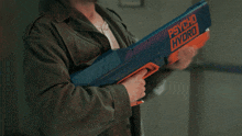 a man in a green jacket holds a psycho hydro water gun