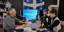 a group of people are sitting around a table with a screen that says brick braces