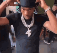 a man is wearing a top hat and a necklace with a number four pendant .