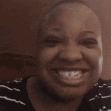 a close up of a woman 's face with a bald head smiling .