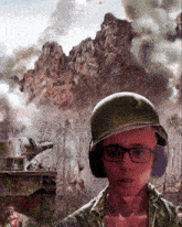 a man wearing glasses and a helmet stands in front of a painting of a battle scene