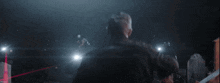 a man in a black jacket is standing in the dark