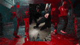 a group of people are standing in a room with blood on the ground