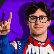 a man wearing glasses and a blue jacket that says sparco is giving a thumbs up
